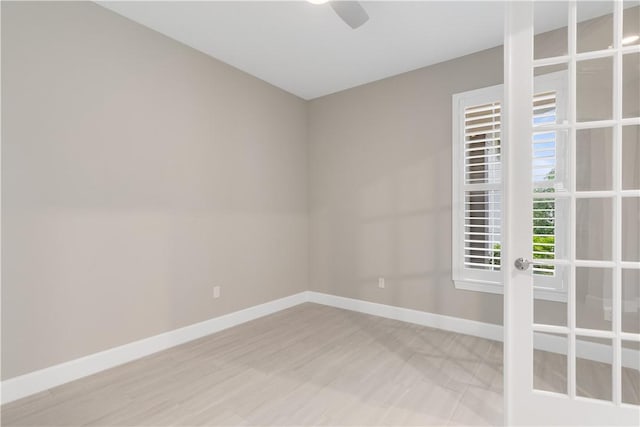 spare room with a ceiling fan and baseboards