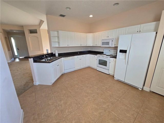 kitchen featuring kitchen peninsula, white appliances, sink, light tile patterned floors, and white cabinetry