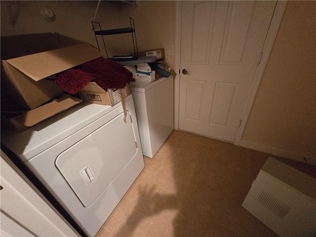 laundry area featuring washer and clothes dryer and light tile patterned flooring