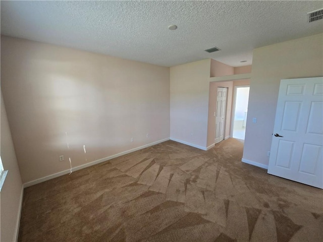 empty room with carpet flooring and a textured ceiling