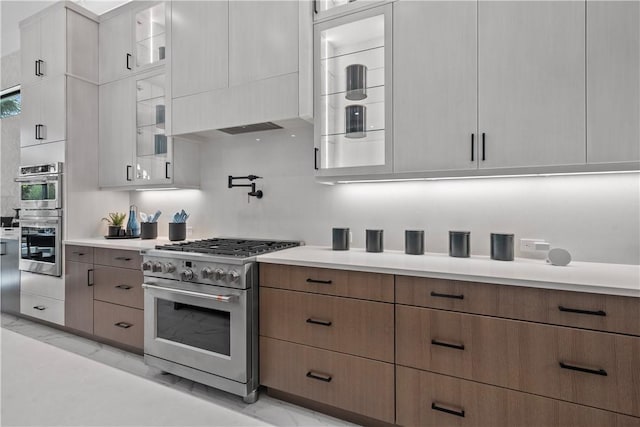 9259 Seaglass Ct, Vero Beach, FL 32963 - kitchen with stainless steel appliances, light marble finish flooring, light countertops, and glass insert cabinets