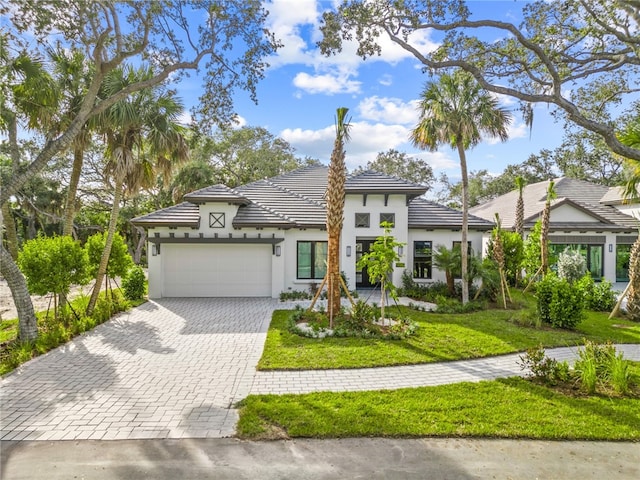 9259 Seaglass Ct, Vero Beach, FL 32963 - view of front of home featuring stucco siding, decorative driveway, an attached garage, and a front lawn