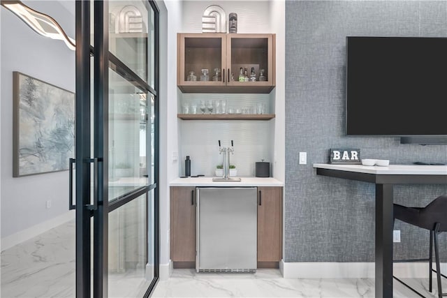 9259 Seaglass Ct, Vero Beach, FL 32963 - indoor wet bar with refrigerator, light marble finish flooring, and baseboards