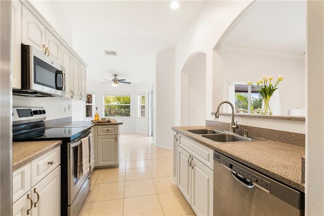 kitchen with light tile patterned floors, white cabinetry, ceiling fan, stainless steel appliances, and sink