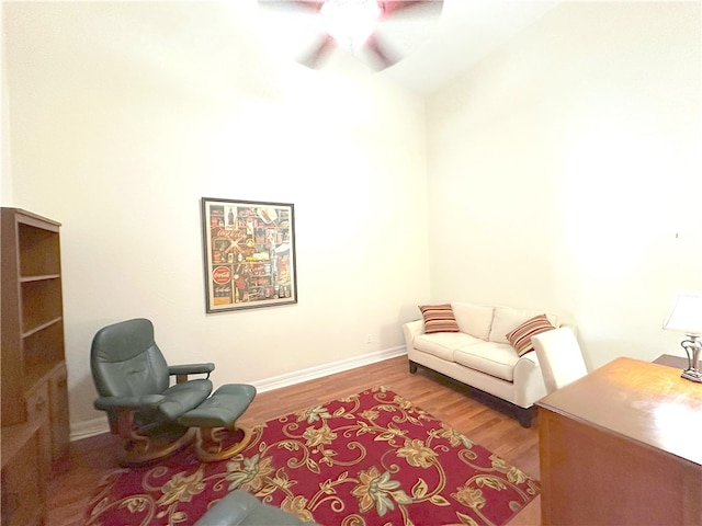 living area featuring hardwood / wood-style flooring and ceiling fan