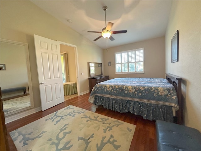 bedroom featuring ceiling fan, dark wood-type flooring, and vaulted ceiling