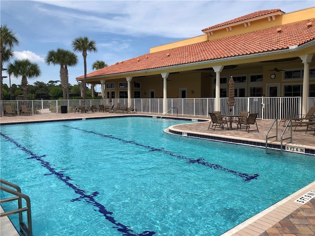 view of swimming pool featuring ceiling fan and a patio