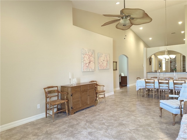 living room featuring high vaulted ceiling and ceiling fan with notable chandelier