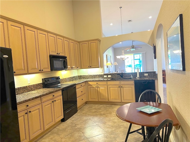 kitchen with ceiling fan, sink, dark stone countertops, pendant lighting, and black appliances