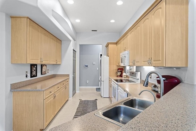 kitchen with white appliances, sink, light tile patterned floors, and light brown cabinets