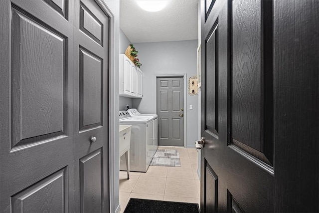 washroom with washer and dryer, cabinets, a textured ceiling, and light tile patterned floors