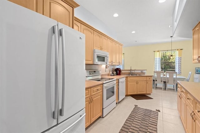 kitchen with white appliances, decorative light fixtures, light brown cabinetry, light tile patterned floors, and sink