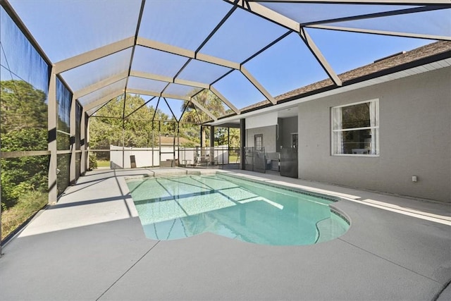 view of swimming pool featuring a patio area and glass enclosure