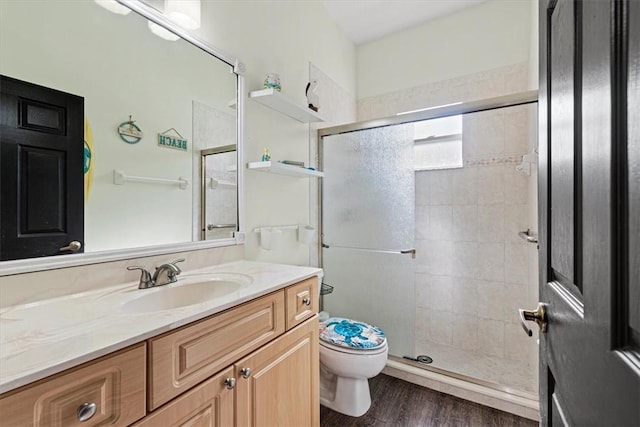 bathroom with toilet, a shower with door, vanity, and hardwood / wood-style floors