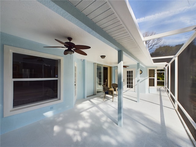 view of patio featuring glass enclosure and ceiling fan