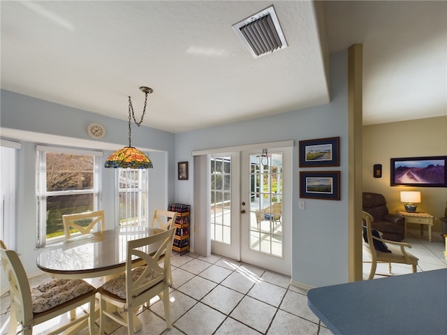 tiled dining space featuring a healthy amount of sunlight and french doors