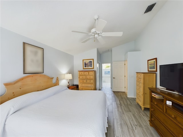 bedroom with ceiling fan, light hardwood / wood-style flooring, ensuite bathroom, and vaulted ceiling