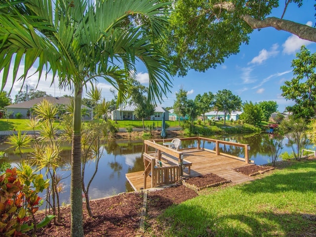 view of dock with a deck with water view and a lawn