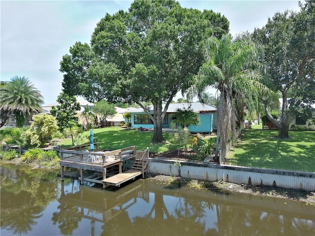 dock area with a water view and a lawn