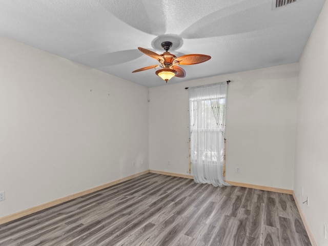 spare room with light hardwood / wood-style floors, ceiling fan, and a textured ceiling