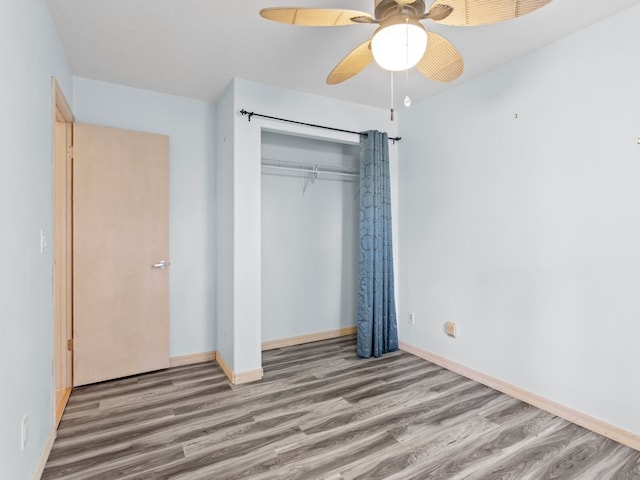 unfurnished bedroom with hardwood / wood-style flooring, ceiling fan, and a closet