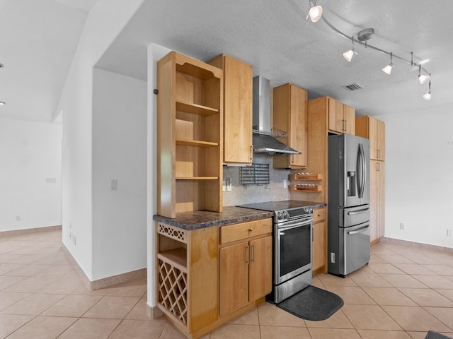 kitchen featuring wall chimney range hood, a textured ceiling, light tile patterned floors, and stainless steel appliances