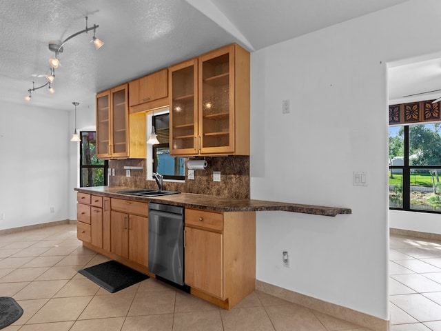 kitchen with stainless steel dishwasher, a wealth of natural light, sink, and decorative backsplash