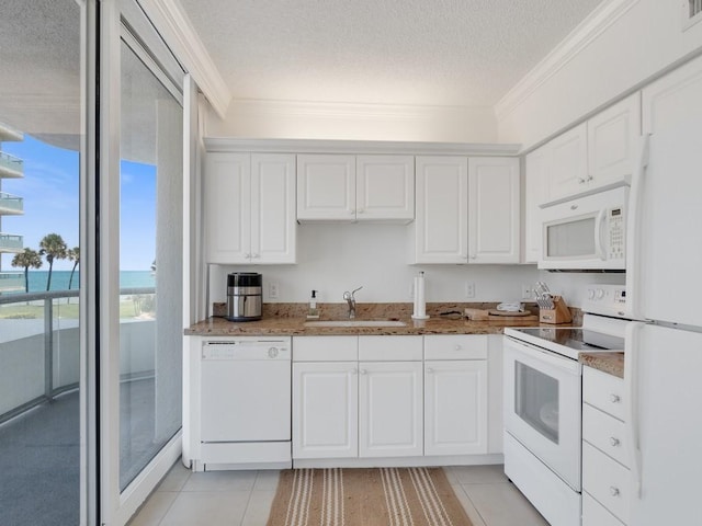 3554 Ocean Dr Unit 202S, Vero Beach, FL 32963 - kitchen with white appliances, a sink, a textured ceiling, light tile patterned floors, and white cabinets