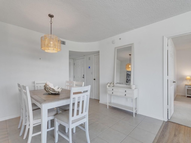3554 Ocean Dr Unit 202S, Vero Beach, FL 32963 - dining area featuring a textured ceiling, light tile patterned floors, and baseboards