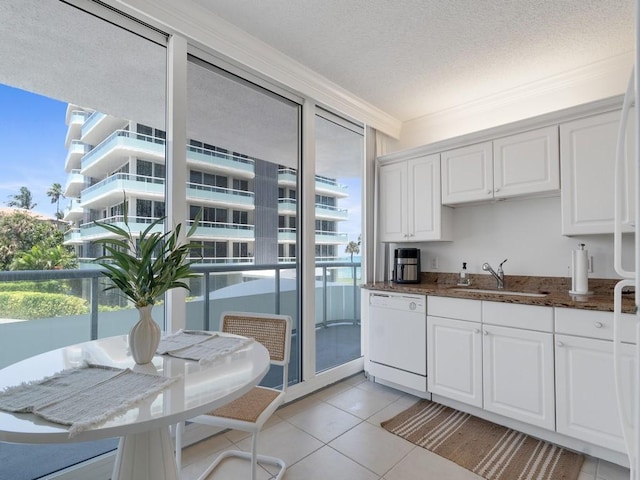 3554 Ocean Dr Unit 202S, Vero Beach, FL 32963 - kitchen featuring white dishwasher, a sink, white cabinetry, crown molding, and light tile patterned floors
