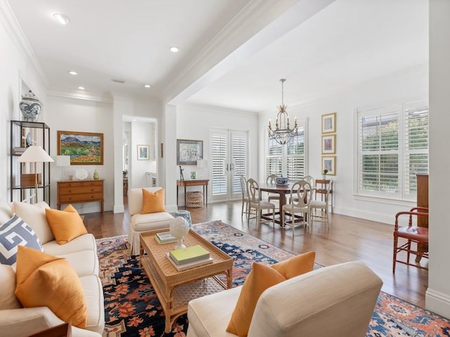 living room featuring wood-type flooring, an inviting chandelier, and crown molding