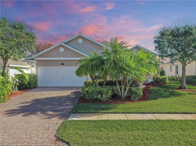 view of front facade with a garage and a lawn