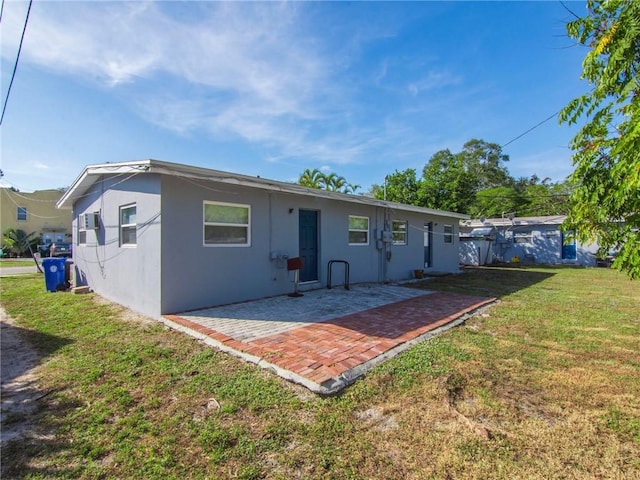 back of property with a yard and a patio