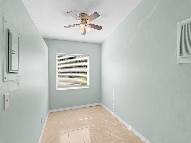 tiled spare room featuring ceiling fan