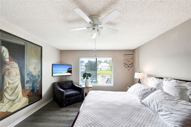 bedroom with a textured ceiling, dark hardwood / wood-style flooring, and ceiling fan