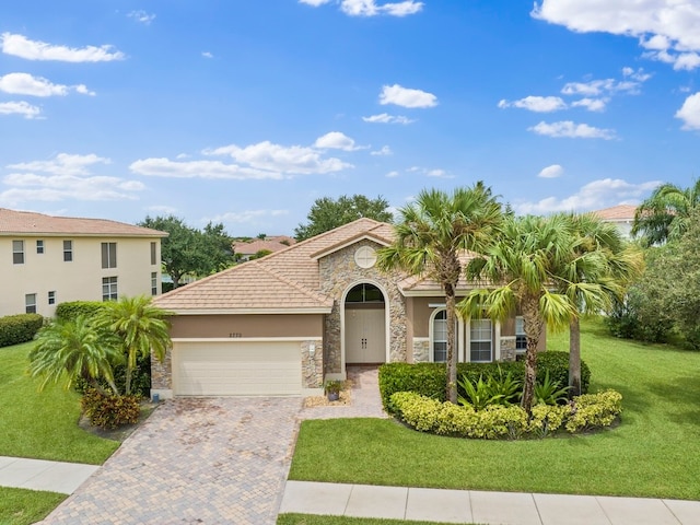 mediterranean / spanish-style home with a garage and a front lawn