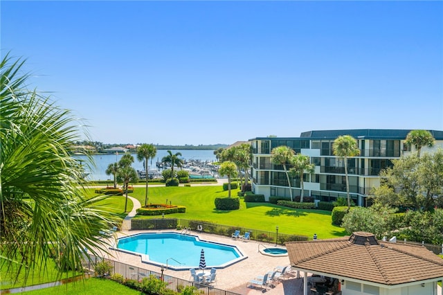 view of swimming pool featuring a water view, a lawn, and a gazebo