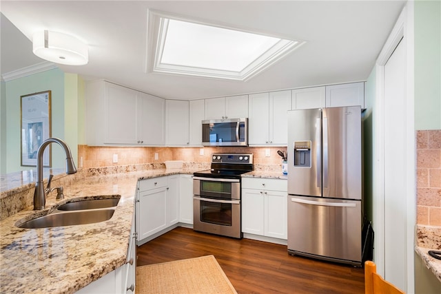 kitchen featuring white cabinets, appliances with stainless steel finishes, sink, and light stone countertops