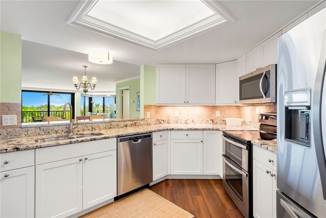 kitchen featuring stainless steel appliances, white cabinetry, and sink