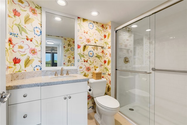 bathroom featuring toilet, vanity, tile patterned flooring, and a shower with shower door