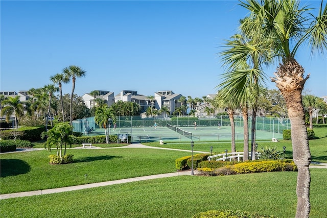 view of tennis court with a yard