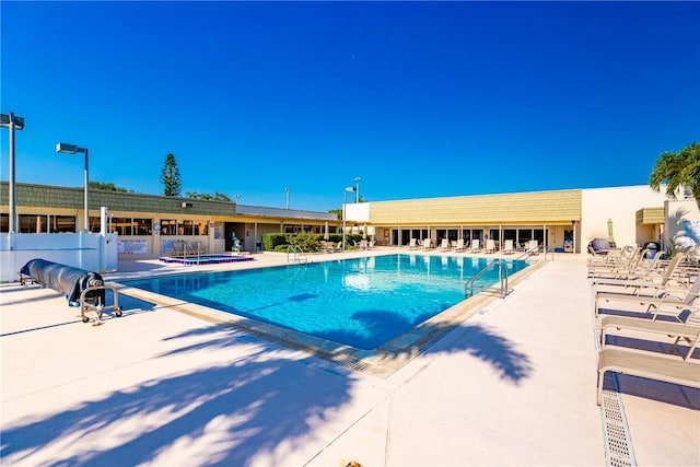 view of swimming pool featuring a community hot tub and a patio area