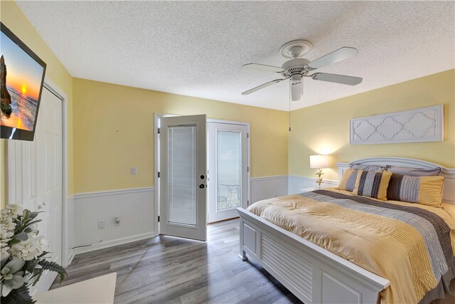 bedroom featuring dark wood-type flooring, a textured ceiling, ceiling fan, and french doors