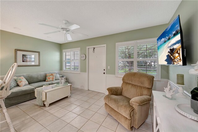 tiled living room with a wealth of natural light, ceiling fan, and a textured ceiling