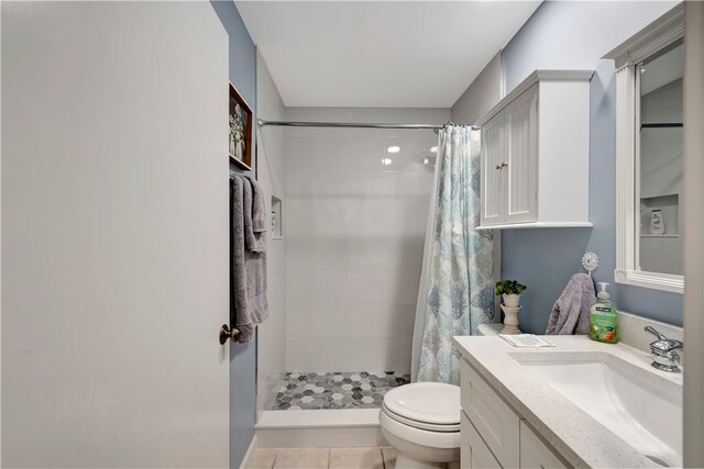 bathroom featuring toilet, vanity, tile patterned floors, and walk in shower