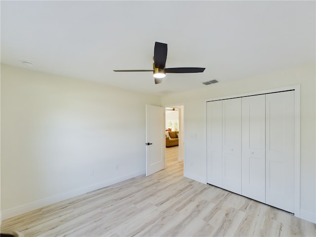 unfurnished bedroom featuring visible vents, a closet, baseboards, light wood-type flooring, and a ceiling fan