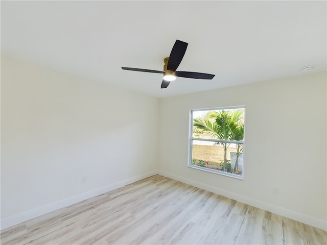 spare room with a ceiling fan, baseboards, and light wood-style flooring