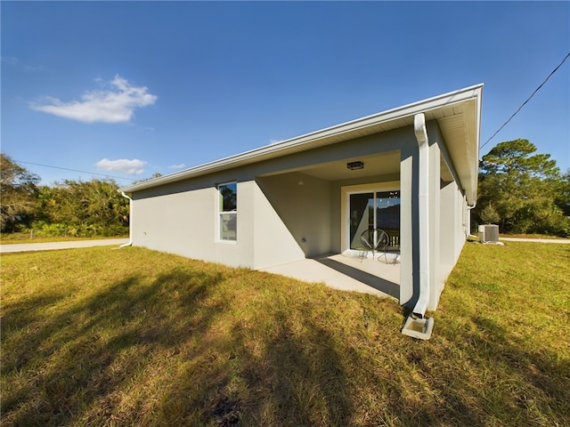 back of property featuring stucco siding, central AC, a yard, and a patio