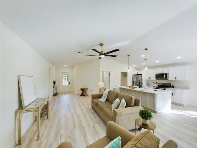 living room with visible vents, light wood-style floors, a ceiling fan, recessed lighting, and vaulted ceiling