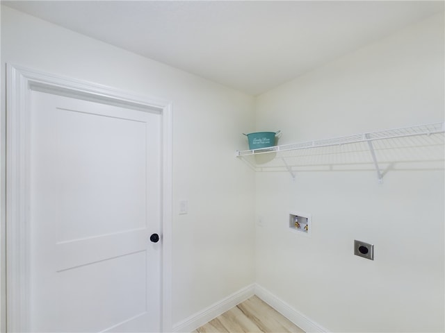 washroom with washer hookup, hookup for an electric dryer, laundry area, baseboards, and light wood finished floors